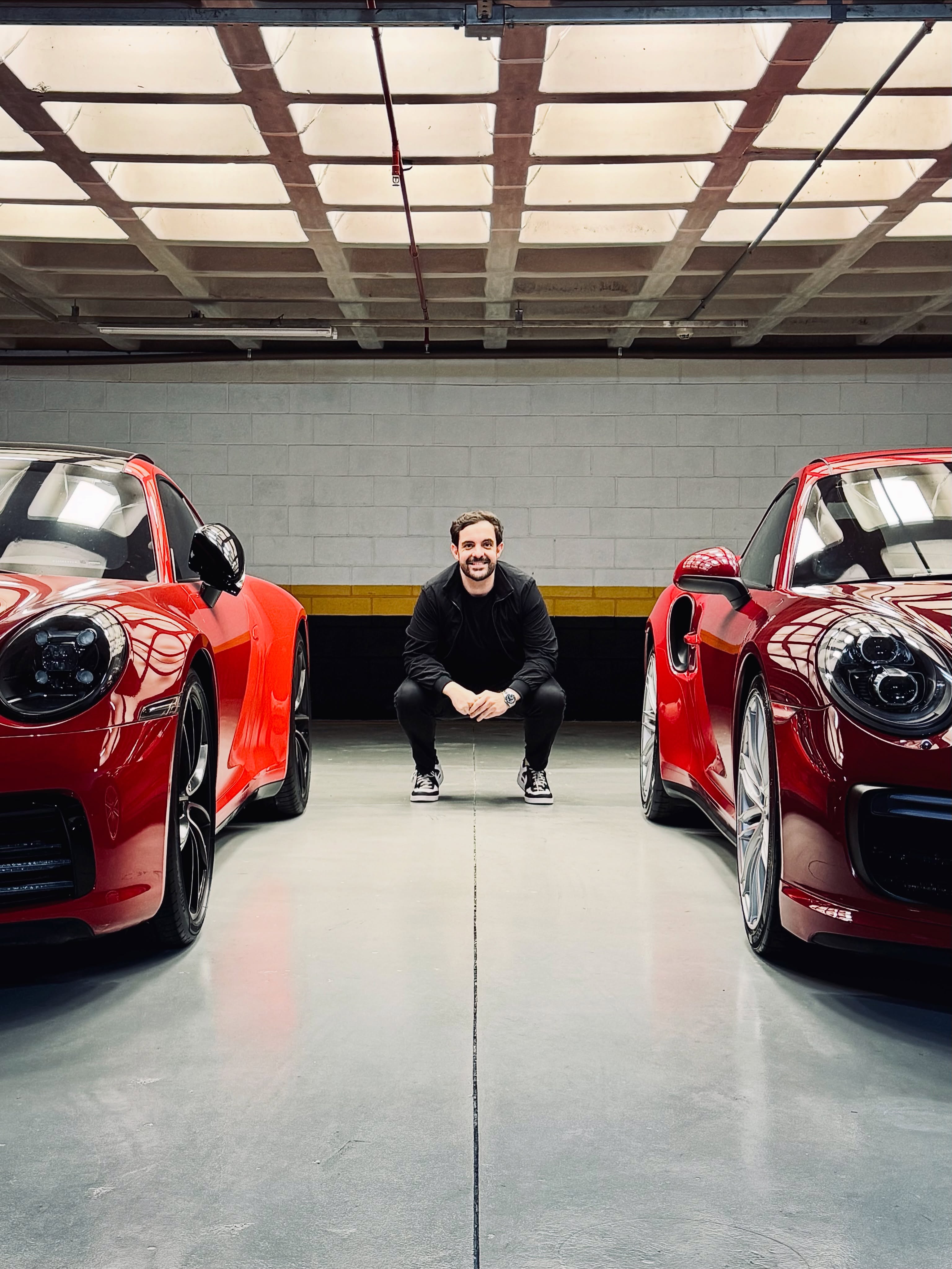 Curadoria German Selection entre dois Porsche vermelhos